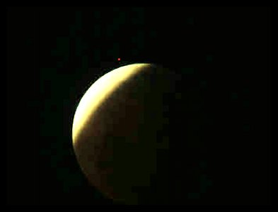 A crescent-lit moon or planet partly in shadow against black space